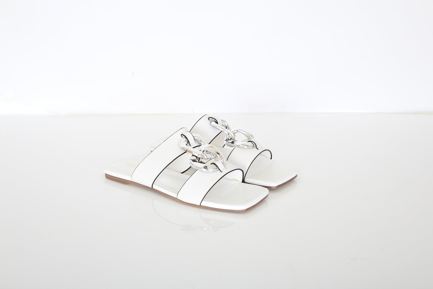 white slippers with decorative chain on top